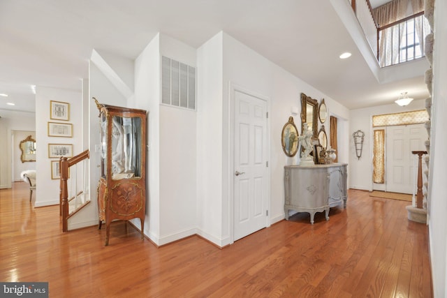 hall with recessed lighting, visible vents, stairway, wood finished floors, and baseboards