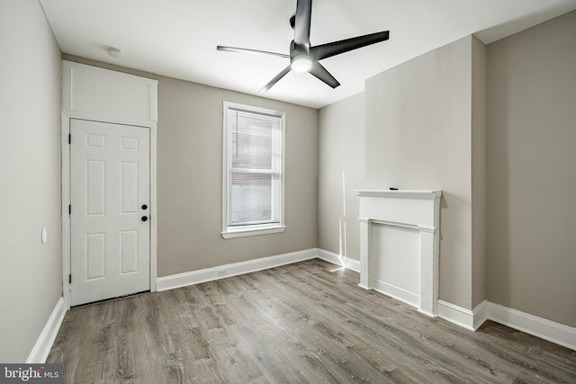 interior space featuring a ceiling fan, light wood-style flooring, and baseboards