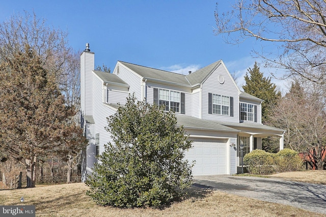 traditional-style home with a garage, aphalt driveway, and a chimney