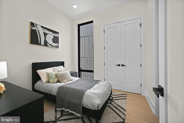 bedroom featuring light wood finished floors, a closet, and recessed lighting