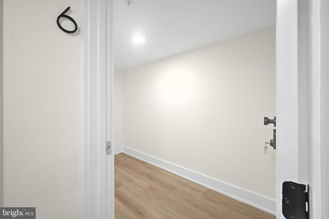 hall featuring light wood-style floors and baseboards