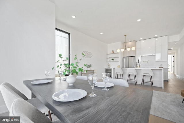 dining room with recessed lighting, beverage cooler, and dark wood-style flooring