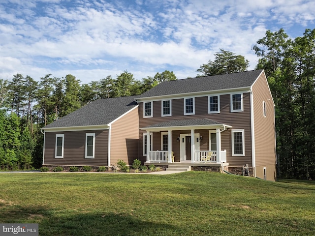 colonial home featuring a front lawn, covered porch, and roof with shingles