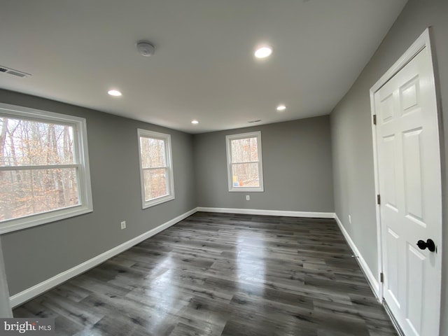 unfurnished room featuring dark wood-style floors, recessed lighting, visible vents, and baseboards