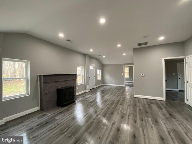 unfurnished living room featuring vaulted ceiling, wood finished floors, and visible vents