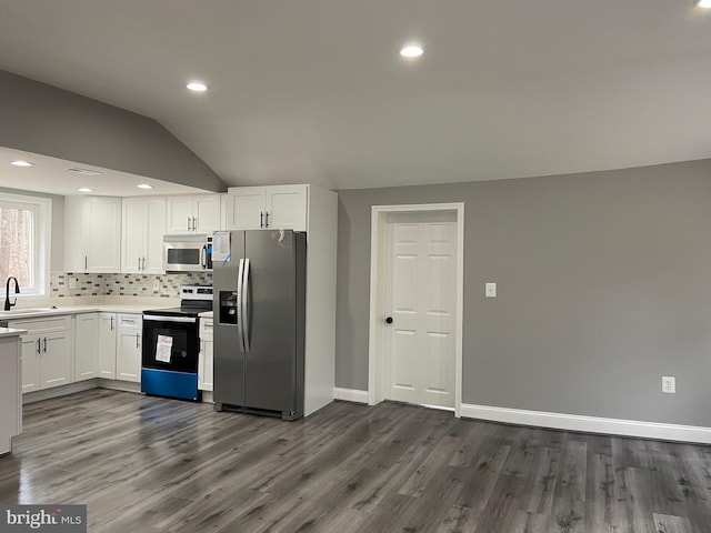 kitchen featuring stainless steel appliances, a sink, white cabinetry, light countertops, and tasteful backsplash