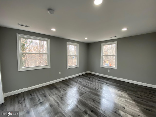 unfurnished room with a wealth of natural light, visible vents, and baseboards