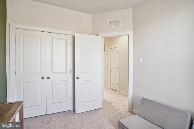 interior space with baseboards, visible vents, a closet, and light colored carpet