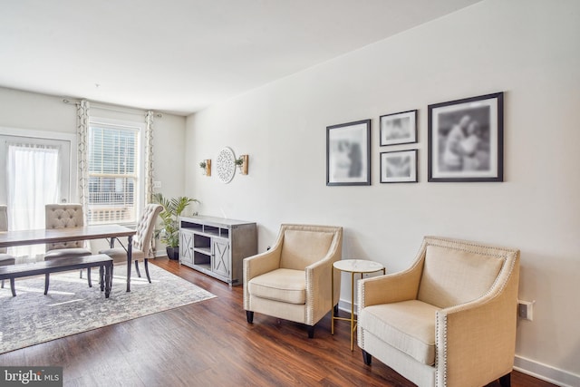 sitting room with dark wood finished floors and baseboards