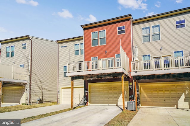 back of property with a garage, driveway, and central air condition unit