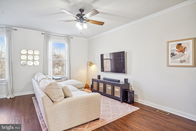 living room with ornamental molding, dark wood finished floors, visible vents, and baseboards