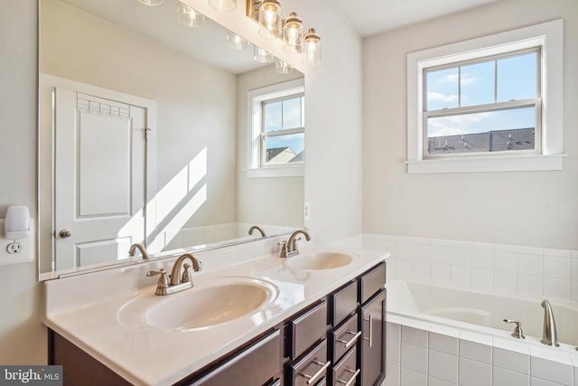 bathroom featuring a bath, double vanity, and a sink