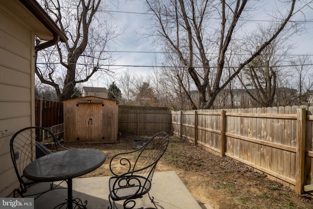 view of patio with an outbuilding, a fenced backyard, and a storage unit