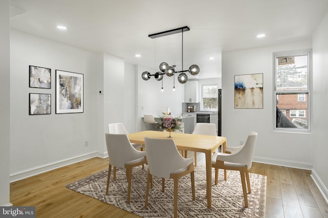 dining area with light wood-style floors, recessed lighting, a chandelier, and baseboards