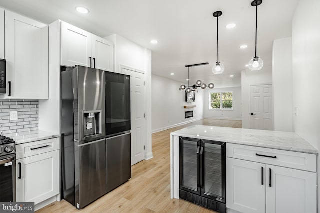 kitchen featuring beverage cooler, stainless steel appliances, and white cabinets