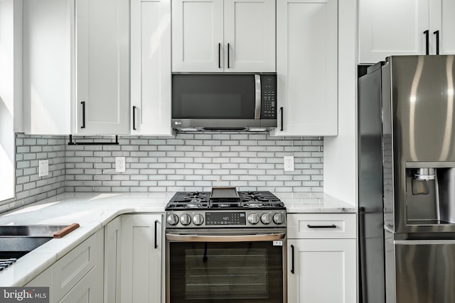 kitchen featuring light stone countertops, white cabinetry, and stainless steel appliances