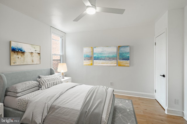 bedroom featuring light wood-type flooring, baseboards, and a ceiling fan