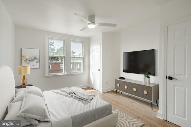 bedroom featuring light wood-style floors, baseboards, and a ceiling fan