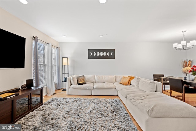 living area with an inviting chandelier, light wood-style flooring, and recessed lighting