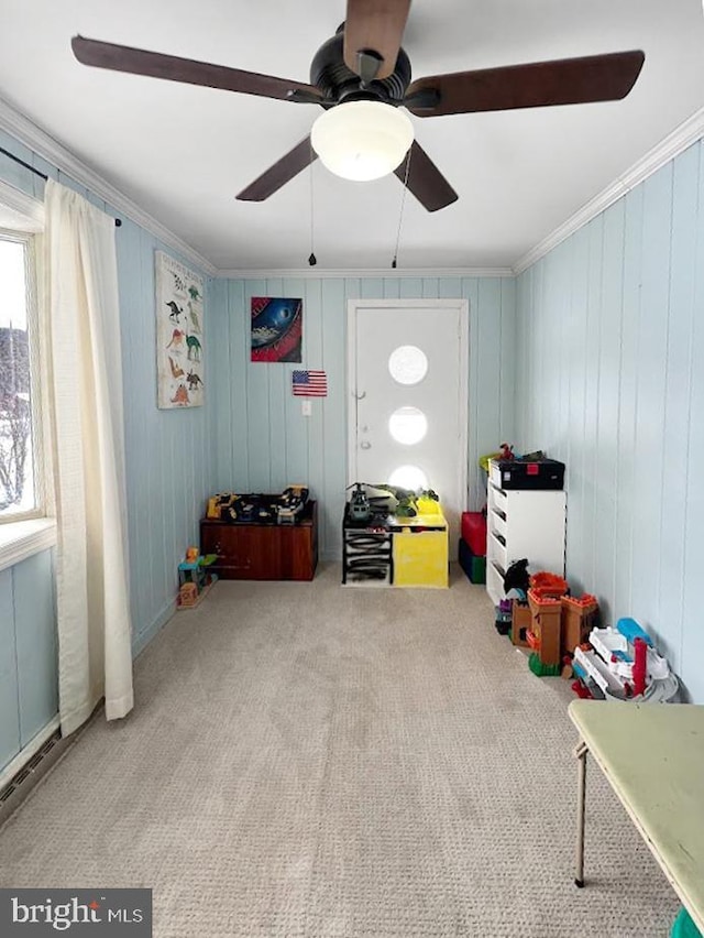 game room with ornamental molding, light colored carpet, and a ceiling fan