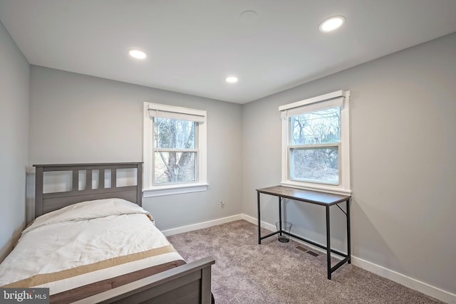 bedroom featuring light carpet, multiple windows, recessed lighting, and baseboards