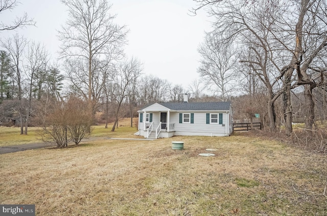 view of front of home with a front yard, fence, and a chimney