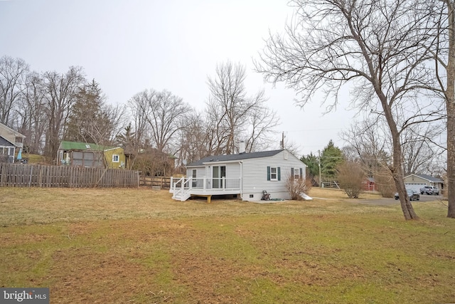 back of house featuring a deck, a lawn, and fence