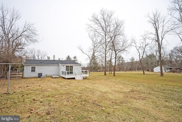 rear view of property featuring a yard and a wooden deck