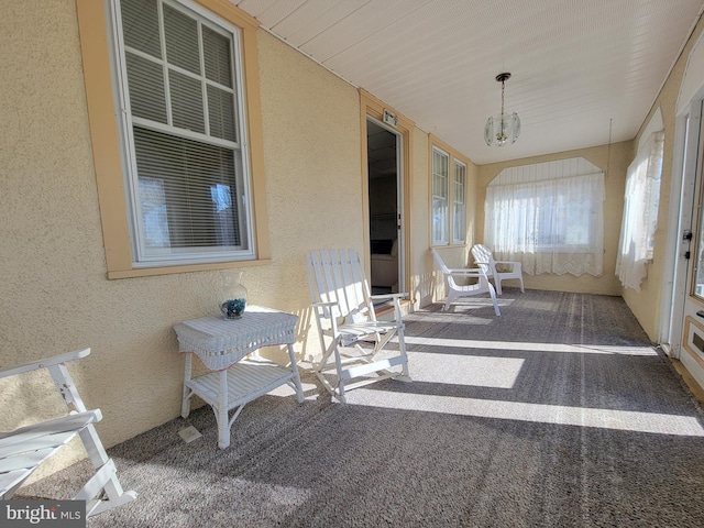 sunroom / solarium with a chandelier