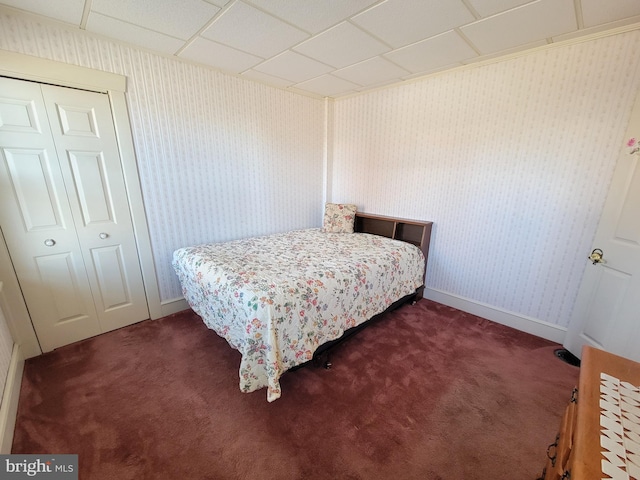 bedroom with baseboards, a closet, carpet flooring, and wallpapered walls