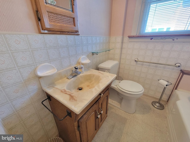 bathroom with toilet, a wainscoted wall, tile walls, vanity, and tile patterned floors