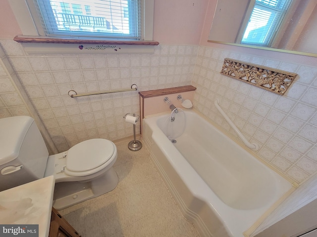 bathroom featuring a bath, tile walls, toilet, and tile patterned floors