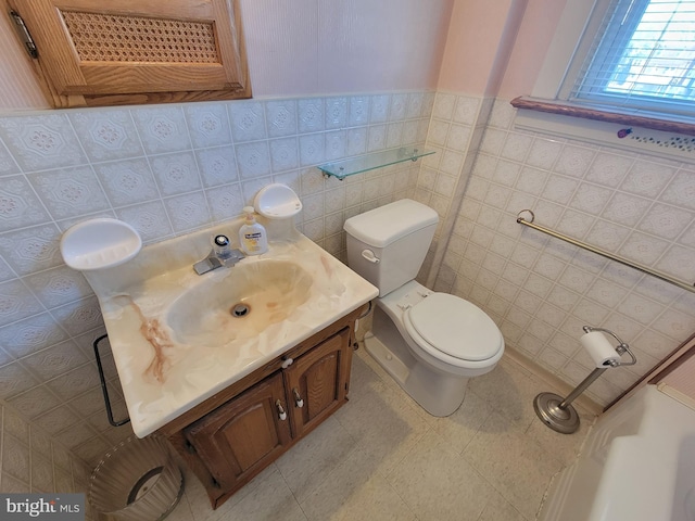 bathroom featuring toilet, tile patterned flooring, tile walls, and vanity