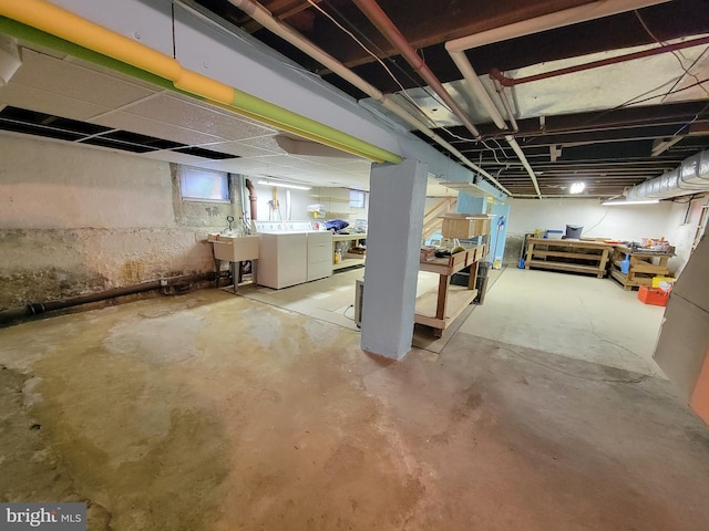 basement featuring a sink and separate washer and dryer