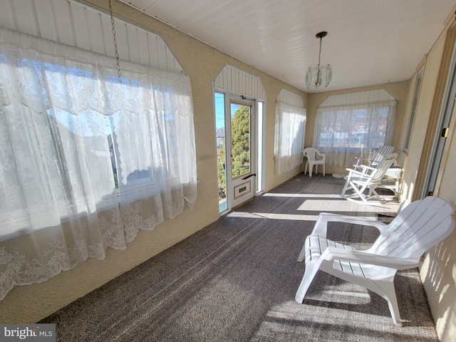sunroom / solarium with an inviting chandelier
