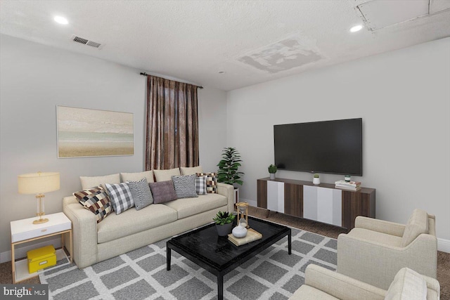 living room featuring a textured ceiling, recessed lighting, visible vents, and baseboards