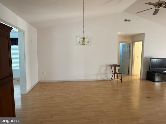 unfurnished dining area with lofted ceiling, visible vents, wood finished floors, and ceiling fan with notable chandelier