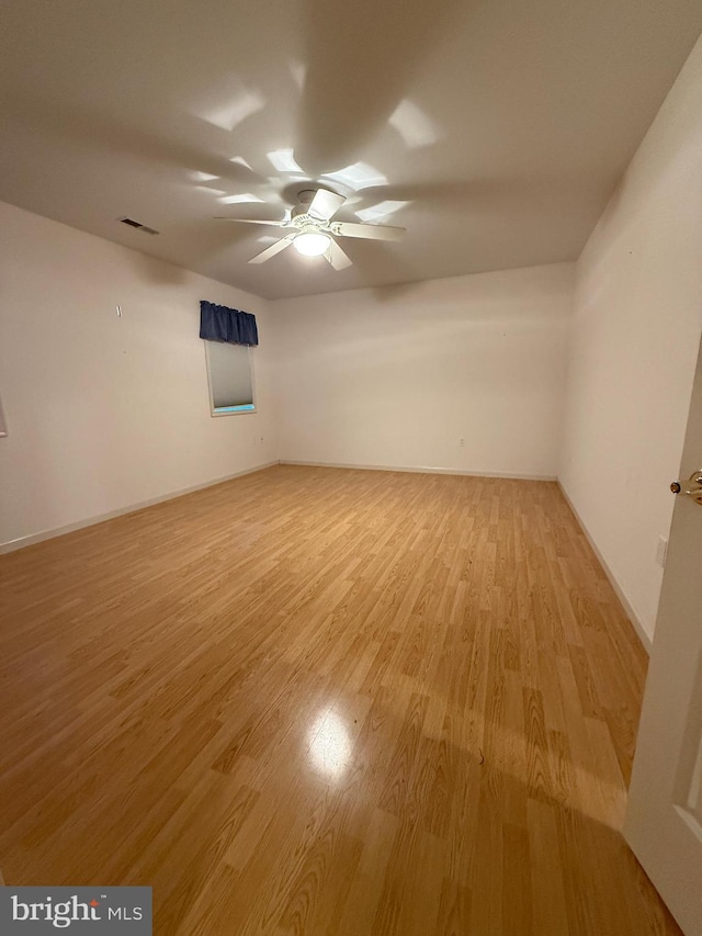 unfurnished room featuring visible vents, baseboards, light wood-style flooring, and a ceiling fan