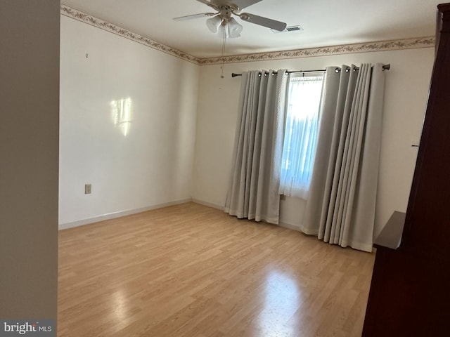 empty room with light wood-type flooring, baseboards, visible vents, and a ceiling fan