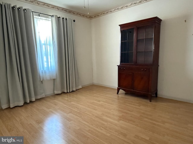 unfurnished room featuring light wood-style flooring and baseboards