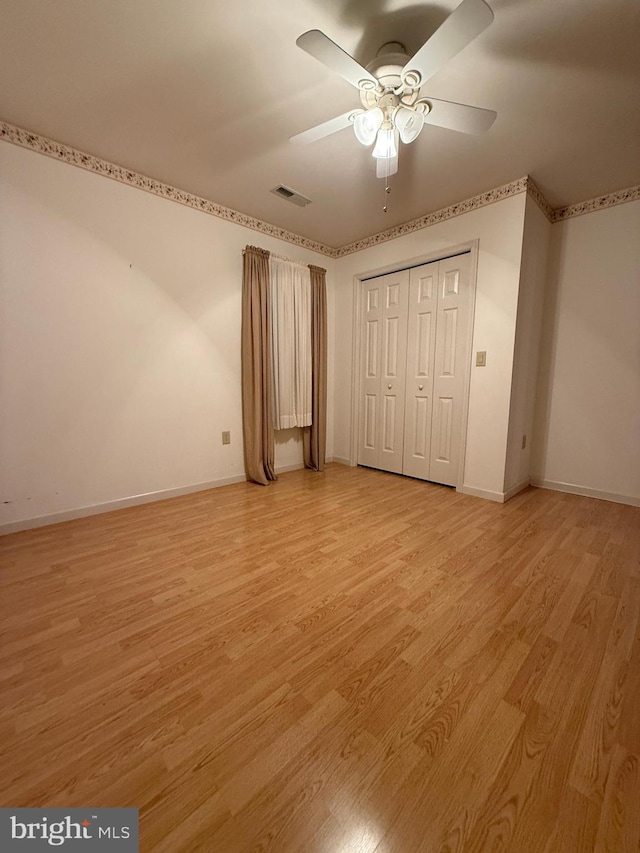 unfurnished bedroom featuring light wood-style flooring, visible vents, ceiling fan, and baseboards