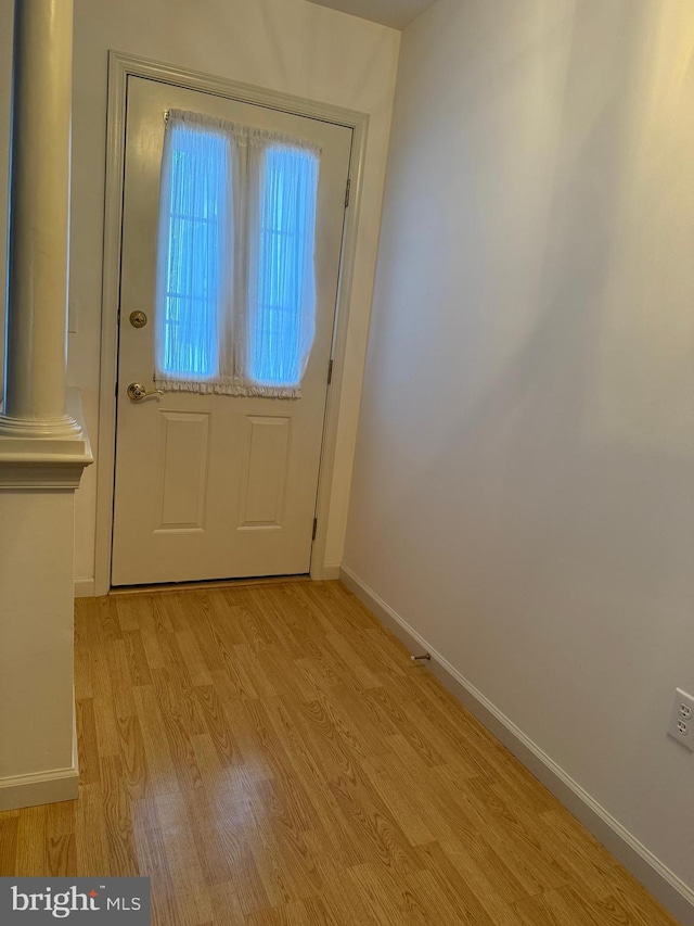 doorway to outside with light wood-style flooring and baseboards