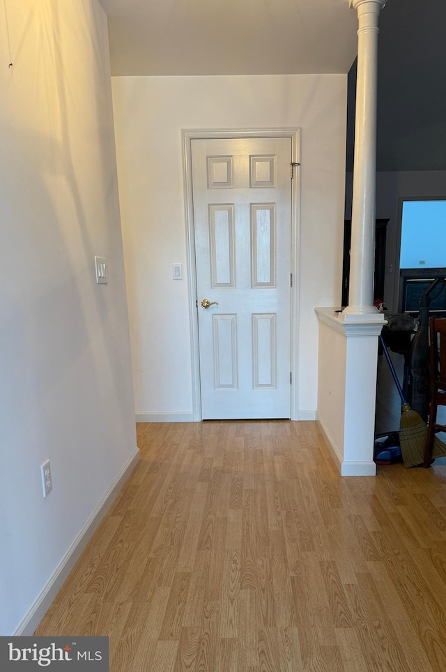 foyer with ornate columns, light wood-style flooring, and baseboards