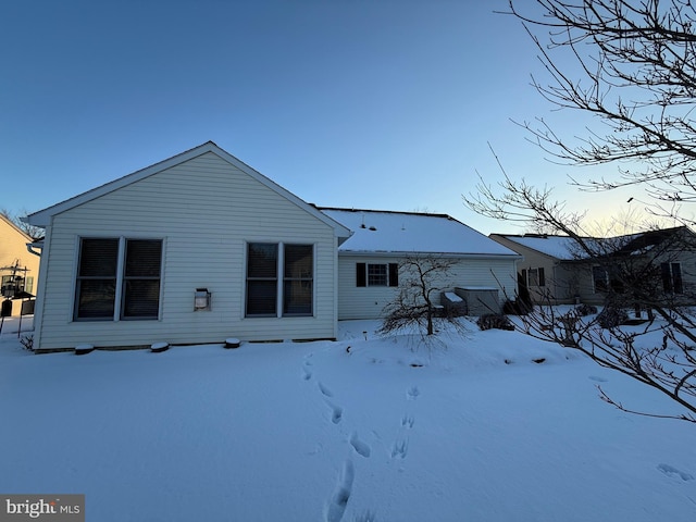 view of snow covered rear of property