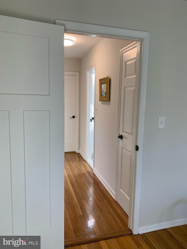 hall with wood finished floors and baseboards