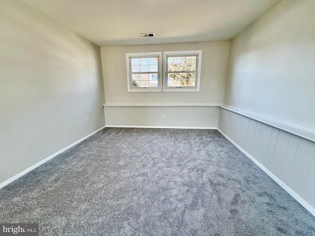 carpeted empty room featuring visible vents and baseboards