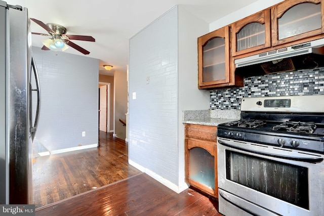 kitchen with stainless steel appliances, brown cabinetry, and under cabinet range hood