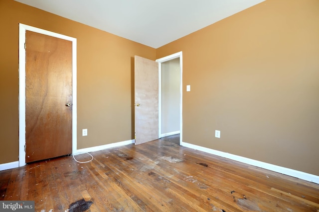 unfurnished bedroom featuring wood-type flooring and baseboards