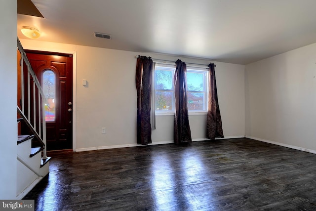 foyer featuring stairs, visible vents, baseboards, and wood finished floors