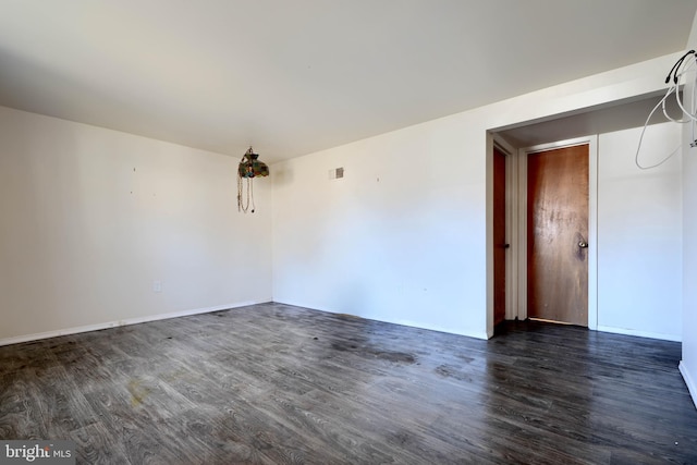 spare room with dark wood-style floors and visible vents